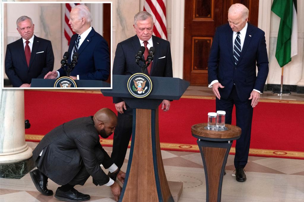 Biden, confused, wanders behind the podium and looks at the ground as Jordan's king speaks
